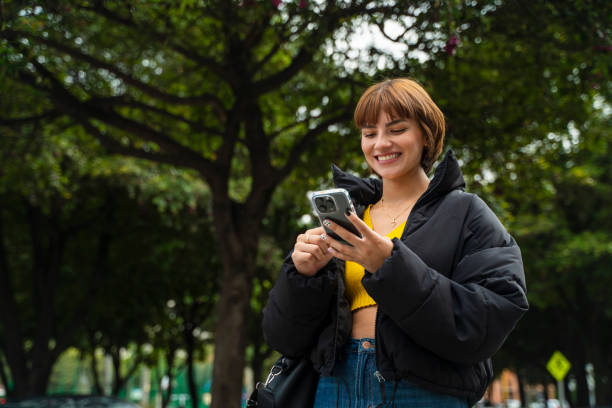 istock latin woman using cell phone on the street 2148389152