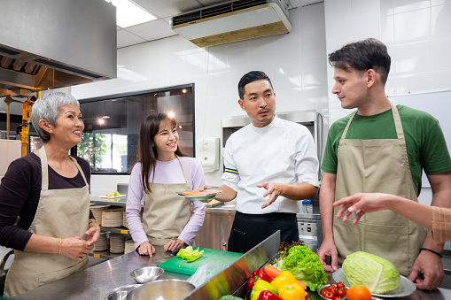 Adults learning from professional chef