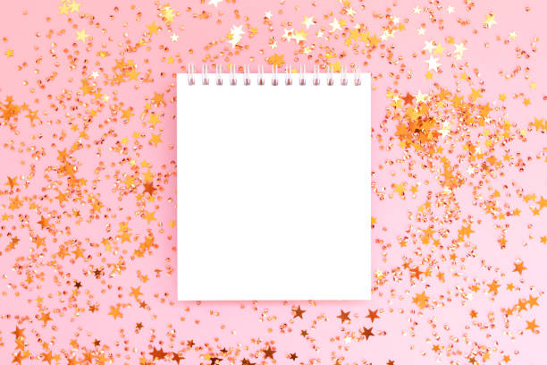 istock Clean notepad mockup and shiny golden stars confetti on a pink background. 2148390757