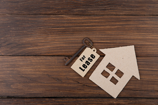 real estate lease concept old key with tag and cardboard house