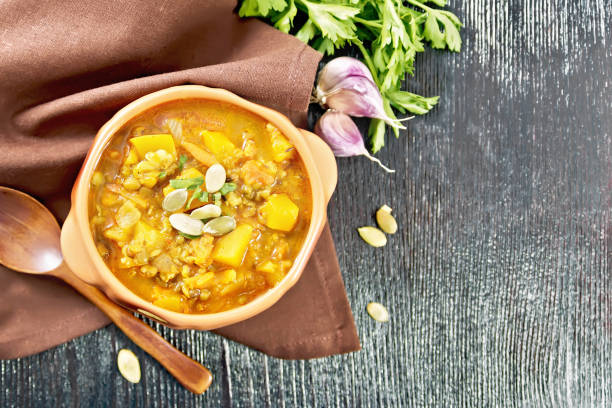 istock Soup-curry with pumpkin and lentils in bowl on dark board top 2148391655