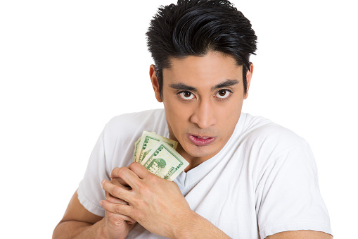 portrait of a greedy young man, holding dollar banknotes tightly, isolated on white background.
