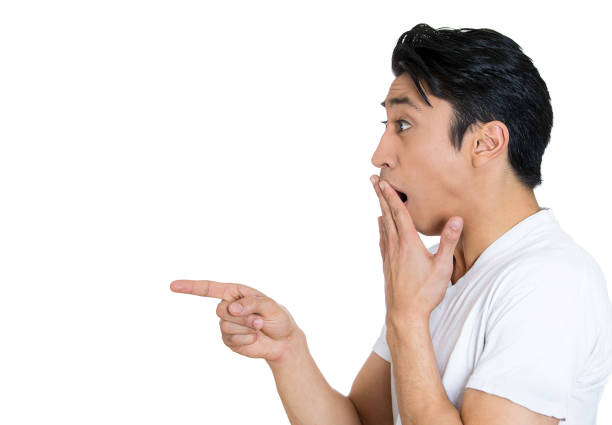 Side profile of a young shocked man pointing finger at someone