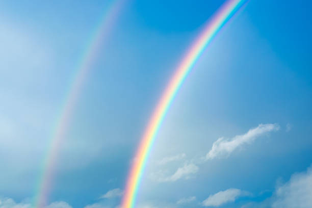 Rainbow over the house after a storm with clouds in the city. Panoramic view of beautiful sunset.