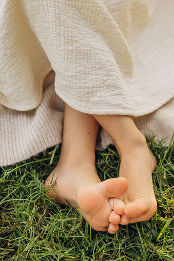 Feet of a girl sitting in a meadow