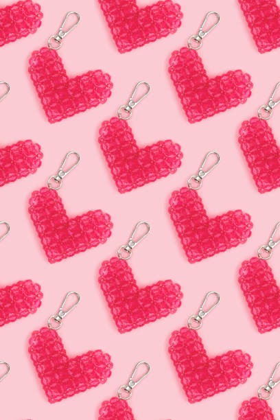 istock Repetitive pattern made from beaded heart keychains on a pink background. 2148392335
