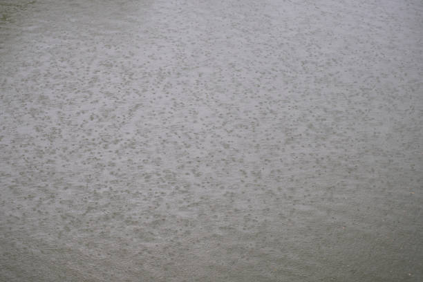 Raindrop descending onto the surface of a lake on a cloudy day