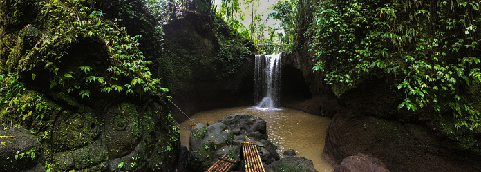 Panoramic shot of Suwat waterfall in Bali after rain. The water looks dirty and brown