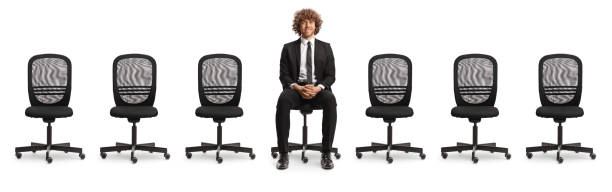 istock Empty office chairs and a young professional man sitting in the middle 2148393739