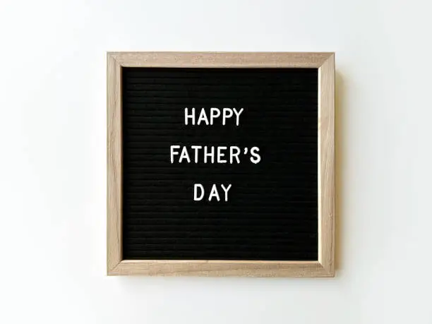 Happy Father's day spelled on the black letter board with white letters, isolated on white background.