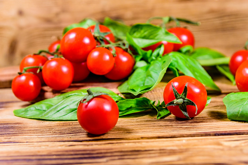 Heap of small cherry tomatoes on rustic wooden table