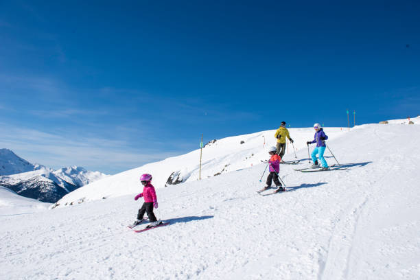 istock Family skis down slope at ski resort 2148397055