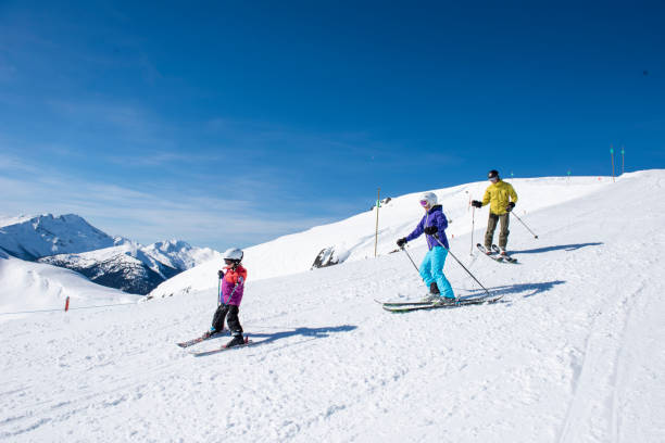 istock Family skis down slope at ski resort 2148397057
