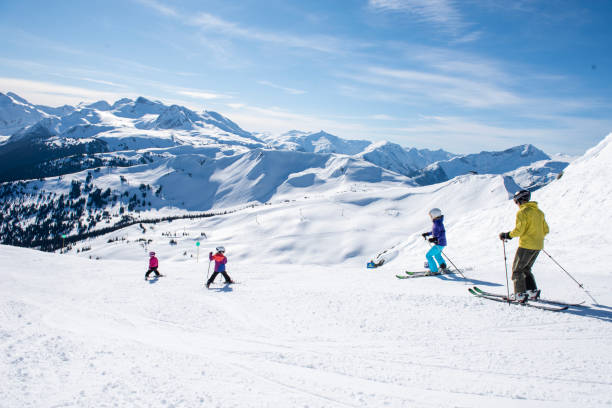 Family skis down slope at ski resort