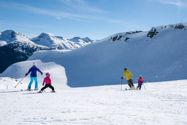 istock Family skis down slope at ski resort 2148397325