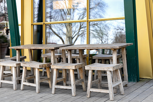 Wooden tables and chairs on the veranda. A place to relax and eat.