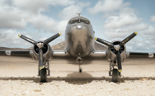 A scale model of the iconic bare-metal DC-3 Dakota in the desert, processed in an old-fashioned style.