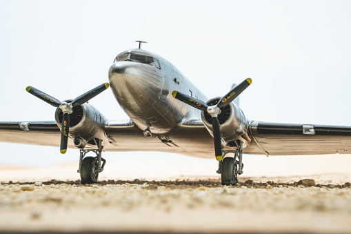 A scale model of the iconic bare-metal DC-3 Dakota in the desert, processed in an old-fashioned style.