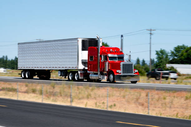 istock Red semi-truck pulling a refrigerated trailer driving on the freeway. 2148400542