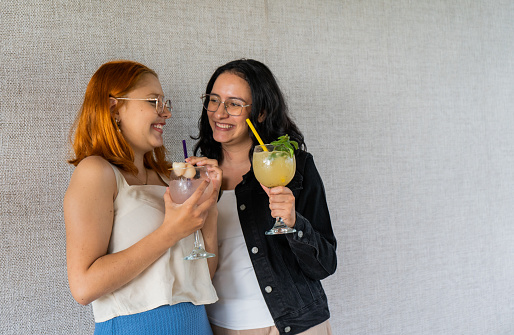 Couple of young women in a restaurant enjoying a cold drink