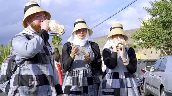 El Pajar, Gran Canaria, Canary Islands, Spain - April 6, 2024 - Romeria de Santa Agueda - Young people from the island La Graciosa with traditional clothes playing the conch shell