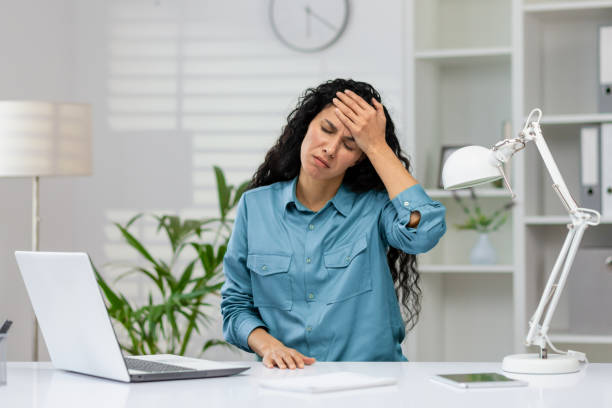 istock Stressed businesswoman with headache at her desk 2148403538