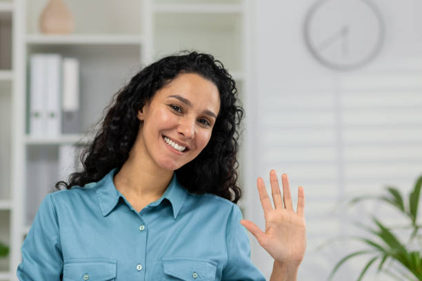 istock Friendly woman waving during a video call at home 2148404478