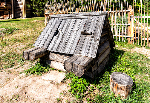 Traditional wooden water well at the countryside in russian village in summer