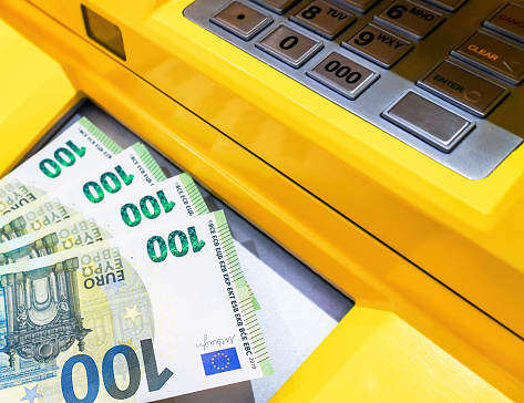 Depositing and withdrawing cash euro banknotes from an ATM. Economic and financial concept
