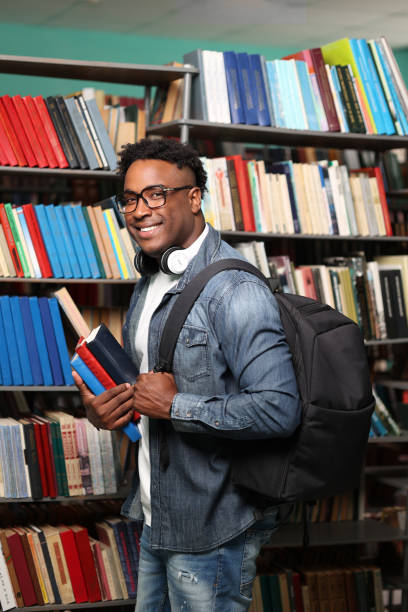 istock African student with backpack and textbooks on background of shelves with books 2148408321