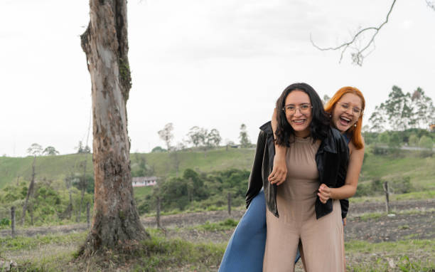 happy smiling and hugging sisters in a field in the open air