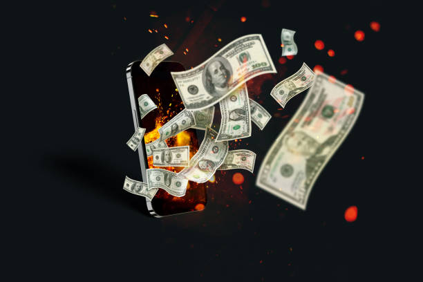 istock Money banknotes fly with sparks and flames from a smartphone on a black background, concept. Online casino and winner, creative idea. Application and finance. Investments and Marketing 2148408907