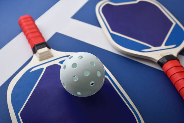 プレイコートの青と赤のピックルボールパドルの詳細 - tennis in a row team ball ストックフォトと画像