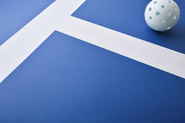 青い競技面に白いピックルボールボールの高架ビュー - tennis in a row team ball ストックフォトと画像