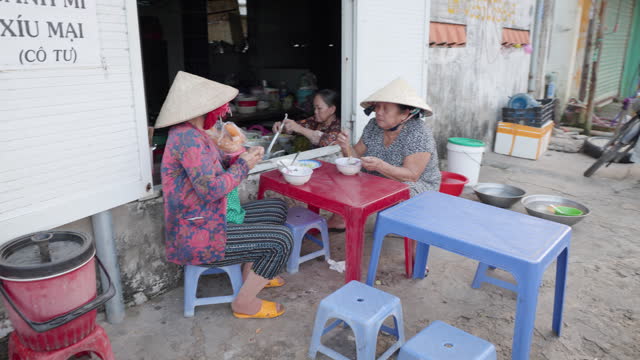 Vietnamese women eating a pho bo, South Vietnam