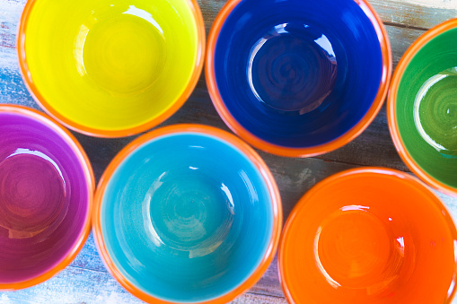 Lineup of vibrant Majorcan ceramic bowls, organized to emphasize their colorful inner surfaces. Part of a series.
