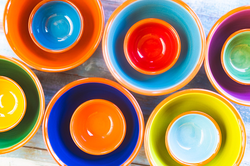 Multiple colorful Majorcan ceramic bowls displayed in a row, highlighting their bright and vivid interiors. Part of a series.