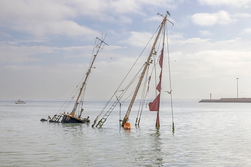Picture of a sunken sailing yacht with masts sticking out of the water near Walvis Bay in Namibia during the day