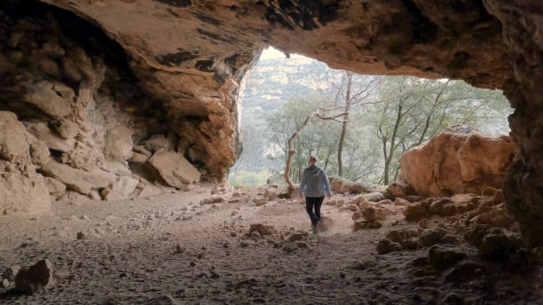 istock Mature woman hikes through cave 2148414157