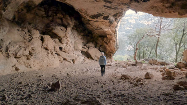 istock Mature woman hikes through cave 2148414175