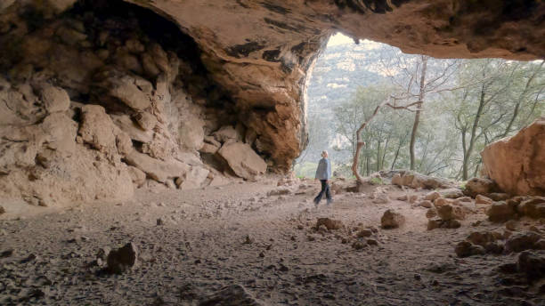 istock Mature woman hikes through cave 2148414185
