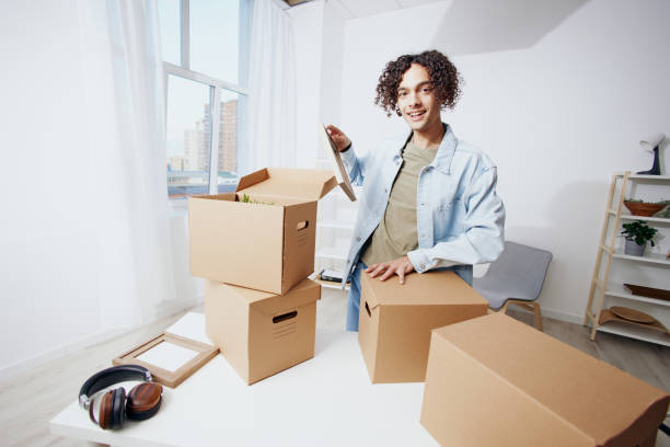 istock guy with curly hair with boxes moving Lifestyle 2148414573
