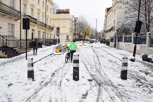 London, UK - December 12 2022: people walk in a snow-covered street in central London