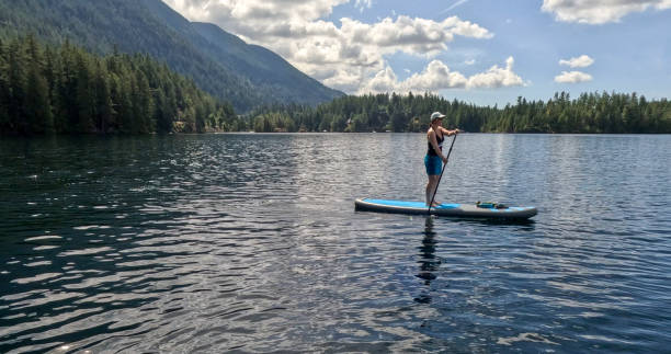 istock Woman paddle boarder explores rugged coastline 2148415090