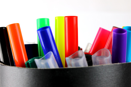 A variety of markers in several selected colors are in a container.