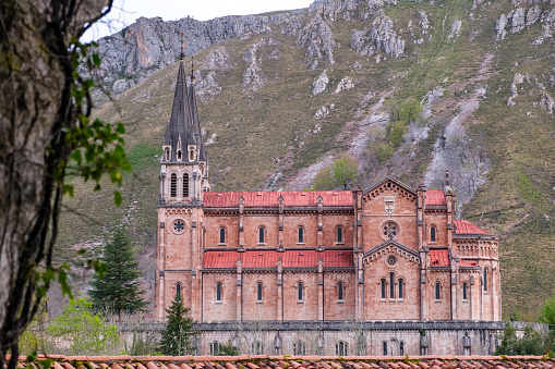 A tall structure standing in Covadonga, Asturias, featuring a grand building with a steeple towering above. The architecture exudes a sense of historic significance and religious reverence.