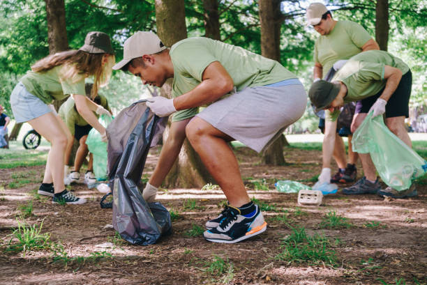 istock Young man volunteer collecting trash in public park 2148417964