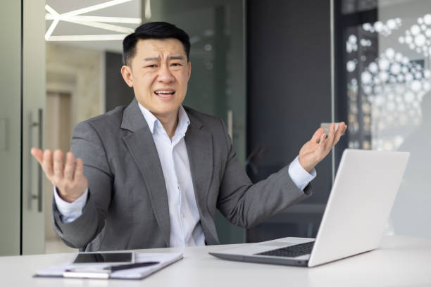 istock Confused Asian businessman at work in office setting 2148419833