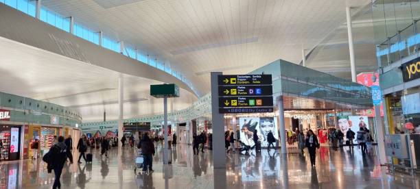 People are hanging out at Barcelona's airport while waiting for their flight.