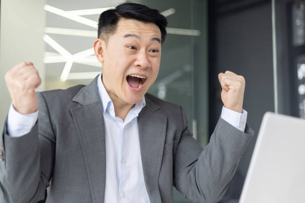 istock Asian business man celebrating success in office 2148421112